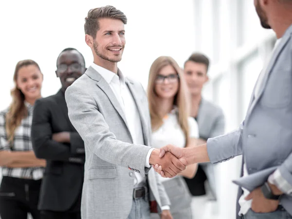 Smiling male boss promoting rewarding handshaking
