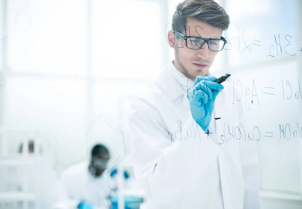 Wetenschapper maken van notities op het glas bestuur ten tijde van het experiment — Stockfoto