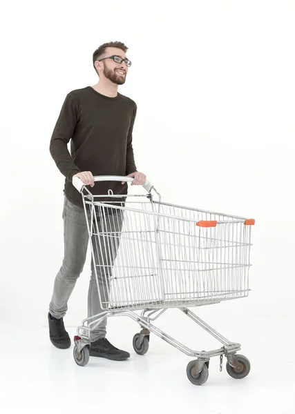Mladý muž s nákupním vozíkem kroky vpřed — Stock fotografie