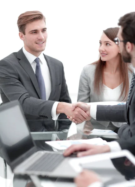 Twee zakenmannen schudden handen met collega 's op de achtergrond. — Stockfoto