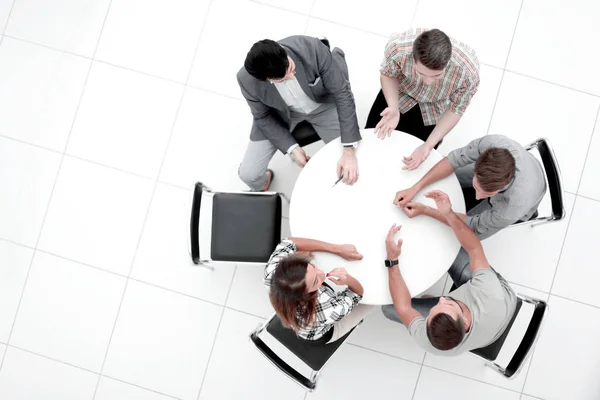 Top view.Manager και δημιουργική ομάδα κάθεται στο στρογγυλό τραπέζι — Φωτογραφία Αρχείου