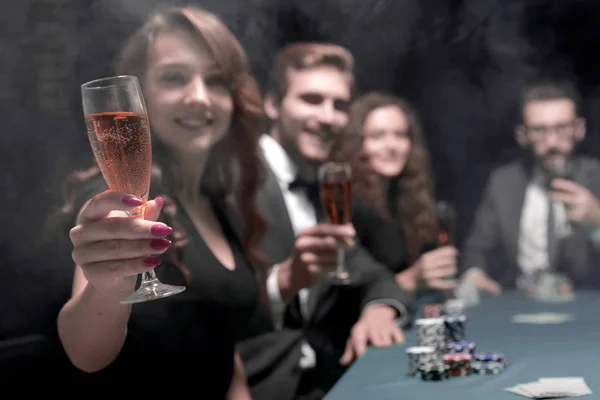 时尚女性与葡萄酒杯, 坐在一个赌场的桌子 — 图库照片