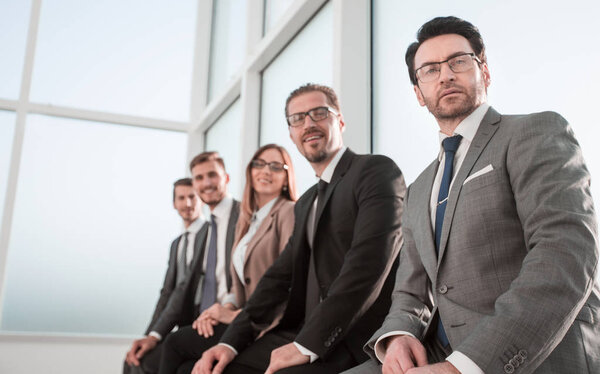 Row of business people waiting for an interview.