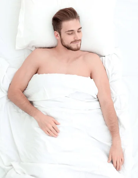 Young man relaxation on the bed top view — Stock Photo, Image