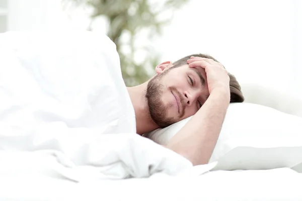 Young man is sleeping in a comfortable hotel room — Stock Photo, Image