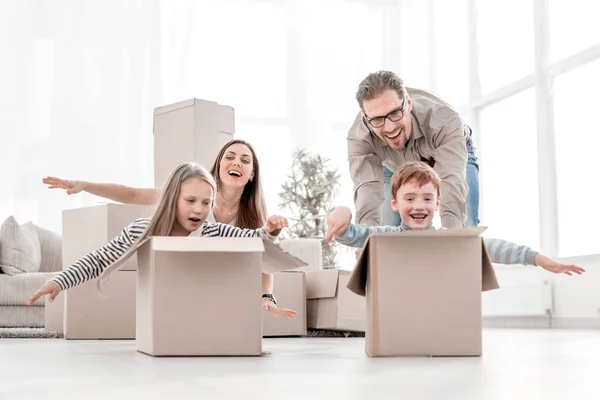 Família divertida usando as caixas para jogar no novo apartamento . — Fotografia de Stock