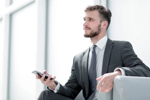 Schöner Geschäftsmann arbeitet an Gadget. — Stockfoto