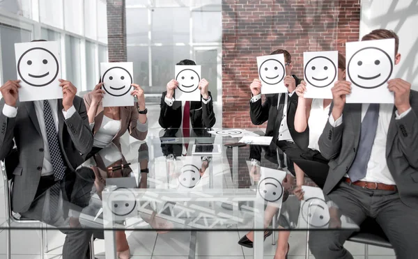Business Team holding a paper with a positive smiley Stock Picture
