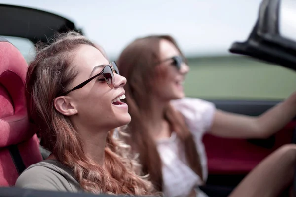 Duas meninas da moda viajam em um carro conversível . — Fotografia de Stock