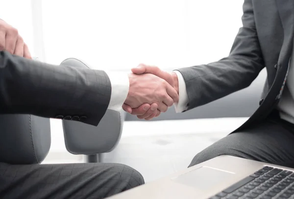 Cerrar up.handshake socios comerciales sobre el escritorio . — Foto de Stock