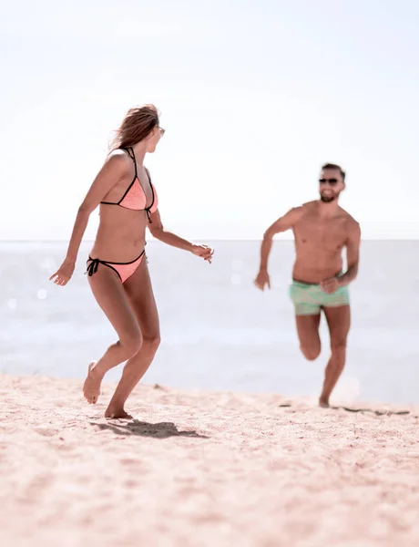 Imagen de amantes felices corriendo por la playa . — Foto de Stock