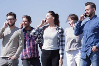 onların akıllı telefonlar üzerinde konuşurken öğrenci grubu.