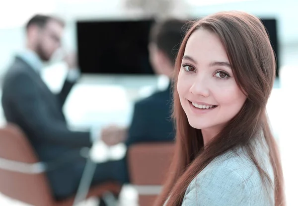 事務所を背景に笑顔の女性アシスタント — ストック写真