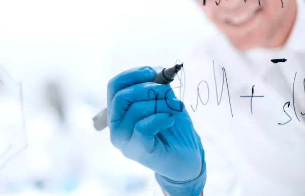 Ein fokussierter Wissenschaftler macht Notizen auf der Tafel — Stockfoto