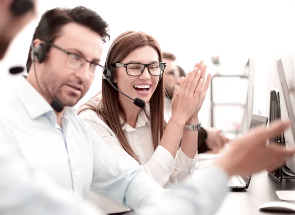 Feliz call center funcionários sentados em sua mesa — Fotografia de Stock