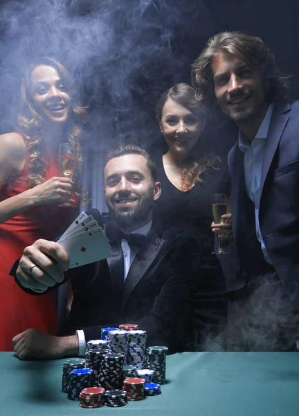 Portret van een groep mensen met drankjes spelen van poker in de casino — Stockfoto