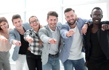 Bir grup insan kamerayı işaret ediyor ve gülümsüyor.
