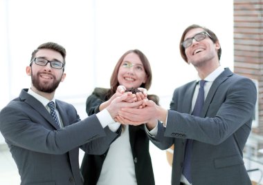 İş ekibi bir taze yeni bitki avuç içinde tutarak,