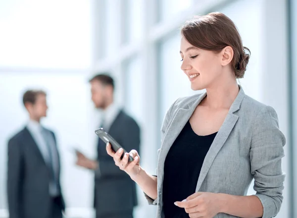 Joven mujer de negocios mirando la pantalla de su teléfono inteligente — Foto de Stock