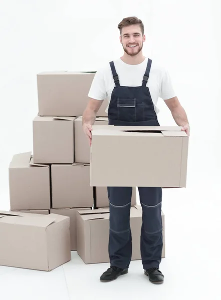 Junger Mann trägt eine Schachtel zum Kartonstapel. — Stockfoto