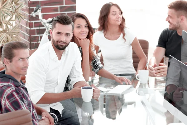 Equipe discutindo novas ideias sentadas em sua mesa — Fotografia de Stock