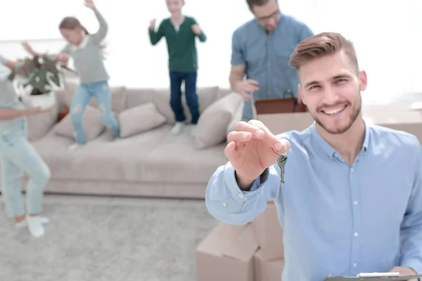 Sonriente agente inmobiliario con llaves en el fondo de un nuevo apartamento — Foto de Stock