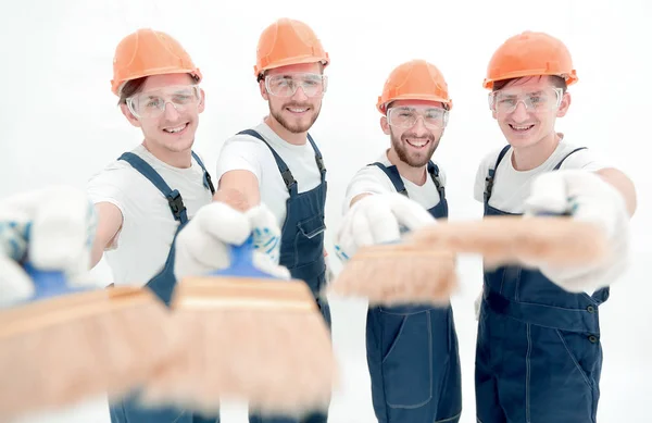 Sorrindo grupo de construtores com uma escova de tinta — Fotografia de Stock