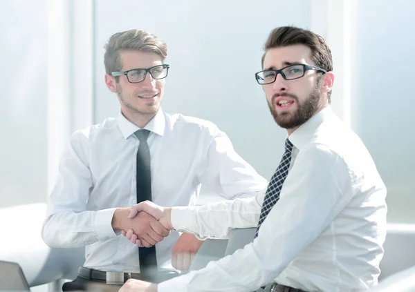 Dipendenti di successo che si stringono la mano seduti alla scrivania — Foto Stock