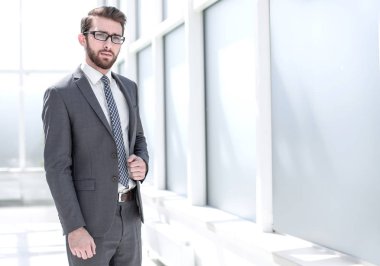 parlak bir ofiste ayakta başarılı iş adamı