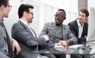 patron ve ofis masasında oturan çalışan el sıkışma