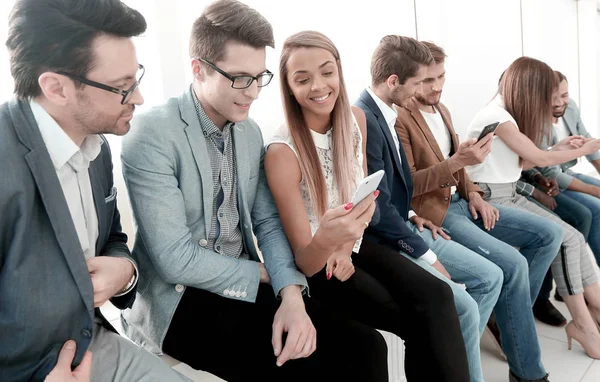 Група молодих людей використовує свої смартфони — стокове фото