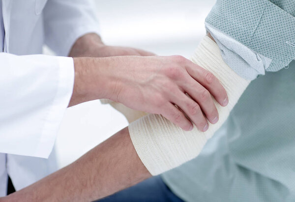 Врач накладывает эластичную повязку
