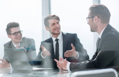 iş arkadaşları masa başında oturan fikirlerini tartışıyor