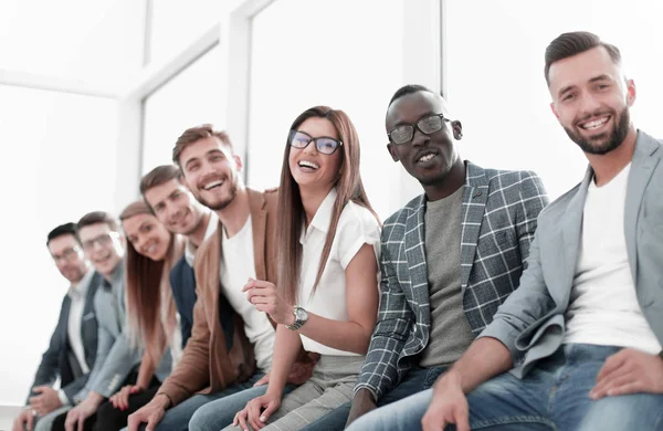 Unga människor som sitter på väggen väntar på sin tur vid intervjun — Stockfoto