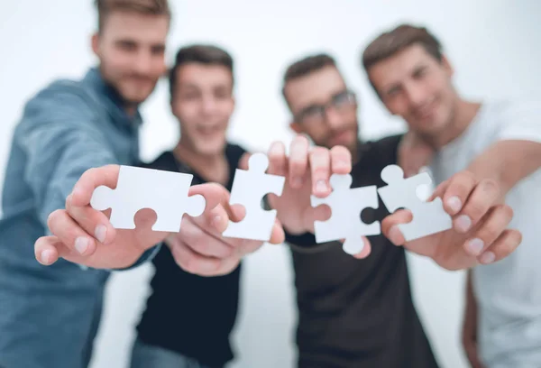 Group of young people with puzzle pieces — Stock Photo, Image