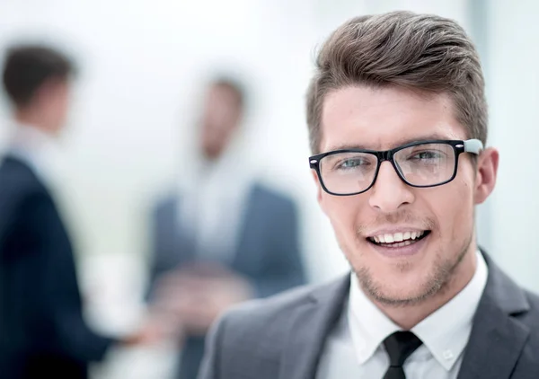 Κλείστε up.smiling νεαρός επιχειρηματίας στο παρασκήνιο γραφείο — Φωτογραφία Αρχείου