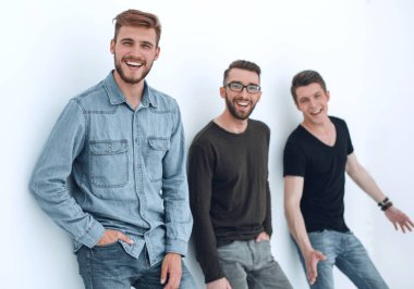 üç kişi duvara yaslanmış gülümseyen