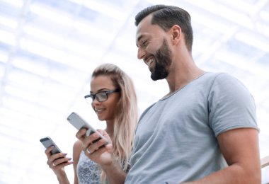 hafif bir arka plan üzerinde smartphone ile genç Çift.