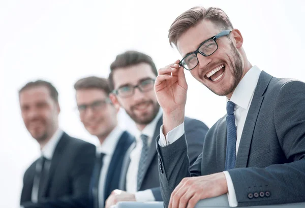 Zamknij up.smiling biznesmen siedzi na tle kolegów — Zdjęcie stockowe