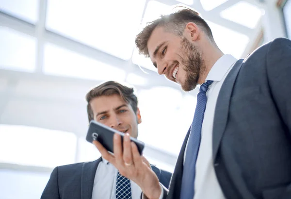 Dos empleados mirando la pantalla del teléfono inteligente — Foto de Stock