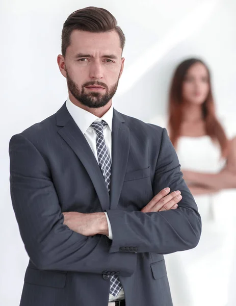 Porträt eines Geschäftsmannes mit einer Frau im Hintergrund — Stockfoto