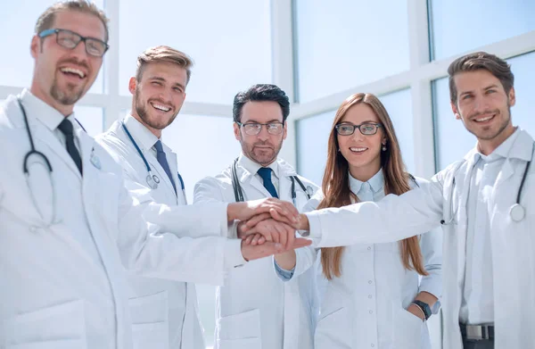 Skupina lékařů s jejich rukama složenýma dohromady — Stock fotografie