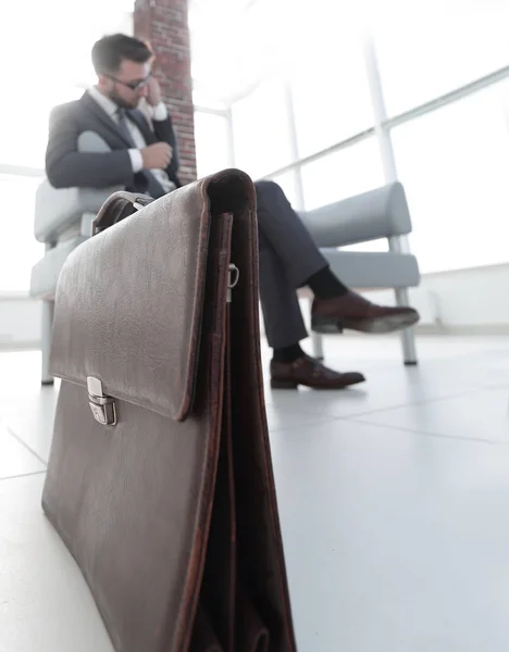 Бізнесмен тримає свій портфель в офісі — стокове фото