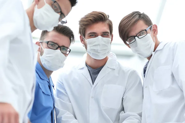 Κινηματογράφηση σε πρώτο πλάνο. μια ομάδα γιατρών σε προστατευτικές μάσκες. — Φωτογραφία Αρχείου