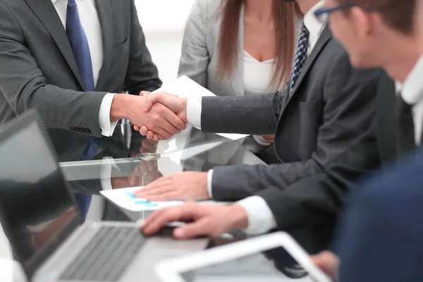 Två affärsmän skakar hand med kollegor på bakgrunden. — Stockfoto