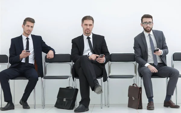 Gruppe von Geschäftsleuten mit Smartphones im Büroflur — Stockfoto