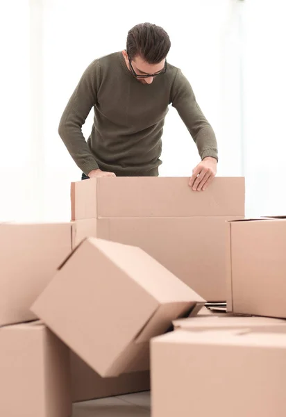 Zelfverzekerde man uitpakken van de vakken in het nieuwe huis — Stockfoto