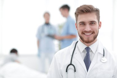 Doktor bulanık arka plan üzerinde gülümseyen