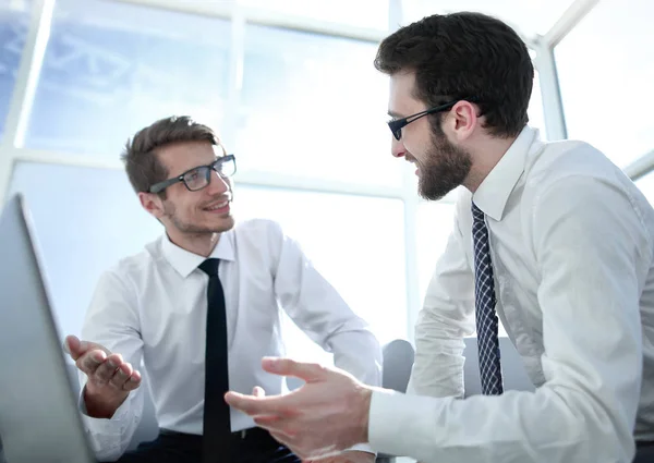 Werknemers bespreken iets zit van een opengeklapte laptop. — Stockfoto