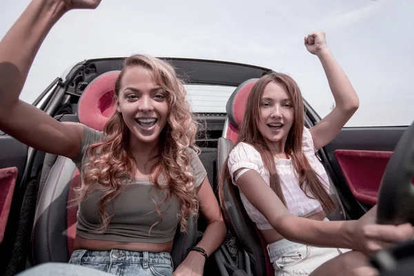 Två glada väninnor på en promenad i en cabriolet — Stockfoto